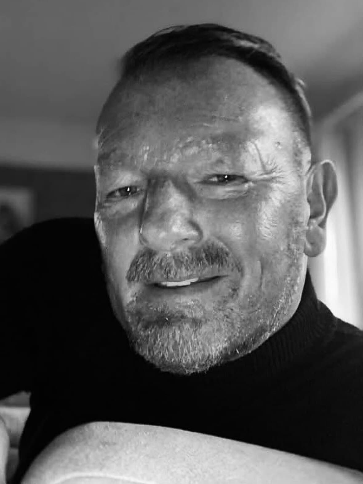Adam Dzielak im schwarzen Rollkragenpullover, Nahaufnahme in Schwarzweiss